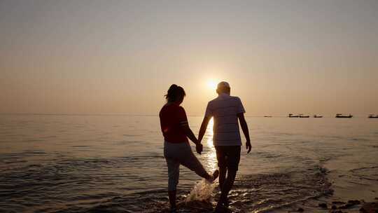 唯美海边日出日落散步的夫妻