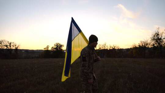穿着制服的年轻男性军人带着乌克兰国旗在乌