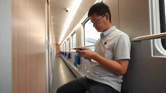 男子在卧铺火车过道上使用手机