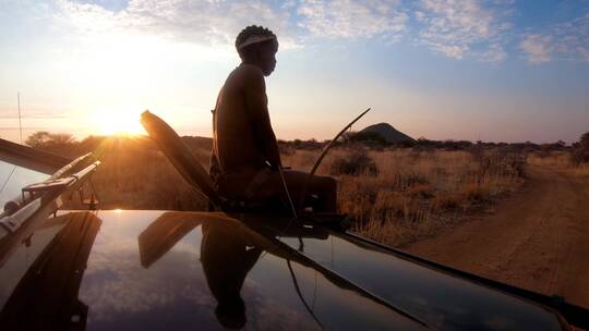黄昏导游坐在一辆狩猎吉普车的前面