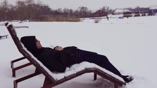 男人在雪地的躺椅上休息