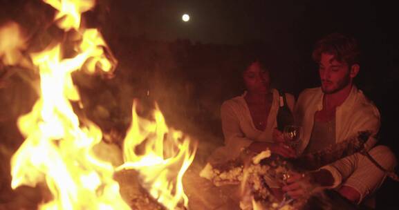 篝火旁喝红酒的情侣