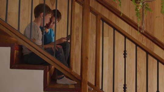 坐在楼梯上看手机的小男孩