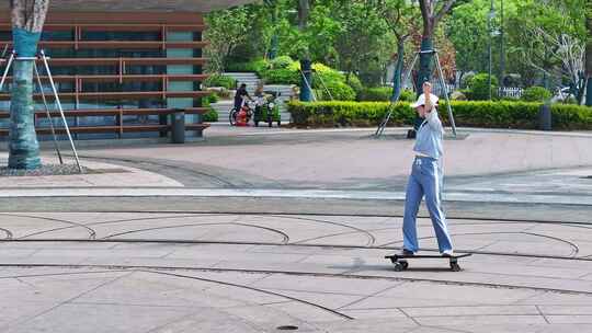 一名年轻美少女在公园广场独自一人练习滑板高清在线视频素材下载