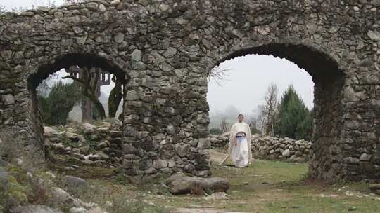 少数民族女子于石拱古迹处站立