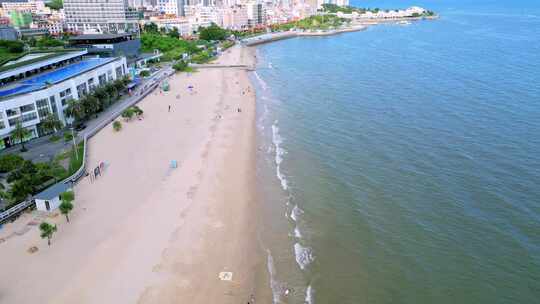 海滨城市高楼边的沙滩和海水景象