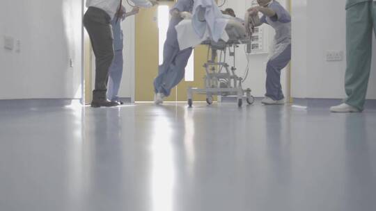 医生推着病床上的病人进入手术室抢救视频素材模板下载
