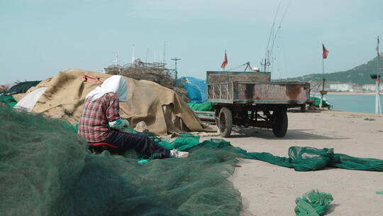 海边码头织补渔网