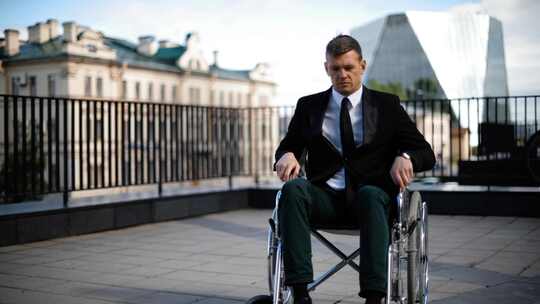 身穿西服残疾人试图从轮椅上站起来视频素材模板下载