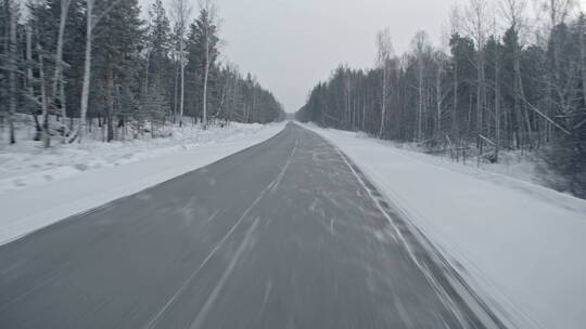 在雪后道路上行驶的开车视角