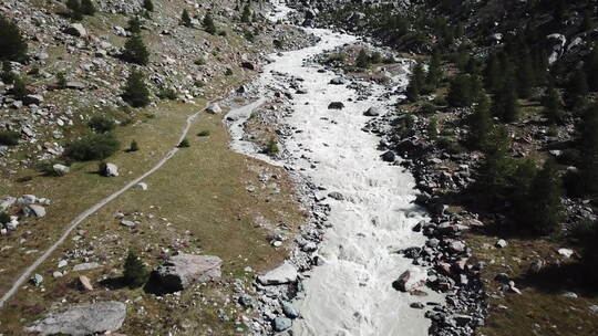 无人机鸟瞰山间河床，水来自冰川融化，瑞士阿尔卑斯山景观视频素材模板下载