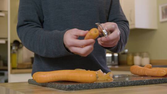 厨房里剥胡萝卜的人特写视频素材模板下载