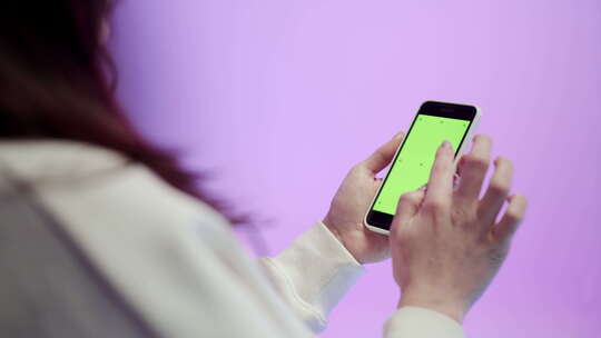 年轻女子使用带有彩色绿色按键屏幕的手机视频素材模板下载