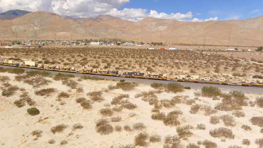 用火车运送的美国军用车辆穿越加利福尼亚沙漠鸟瞰图