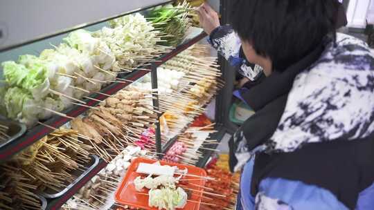 顾客在挑选食材的小吃摊美食场景