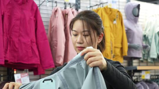 中年女性在服装店选购衣服