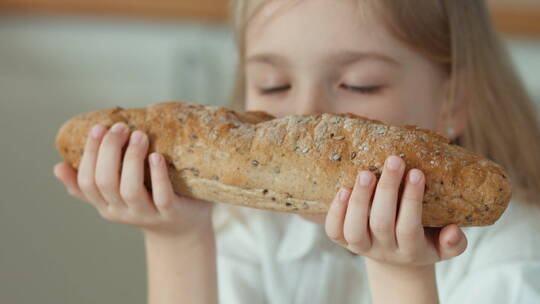 女孩拿起面包放在鼻尖嗅