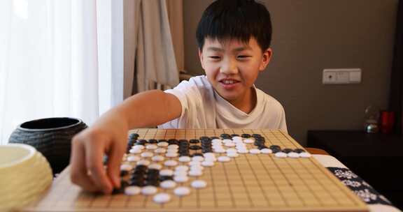 可爱的男孩在窗边下围棋