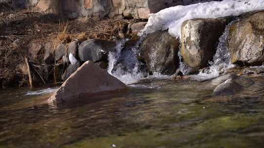 溪边覆雪岩石流水景象