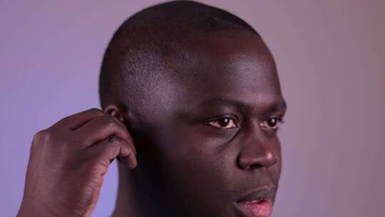 非洲裔美国人戴上一套蓝牙无线耳机。
