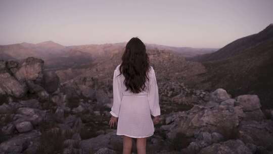 女子站在岩石上眺望远方，自由旅游旅行