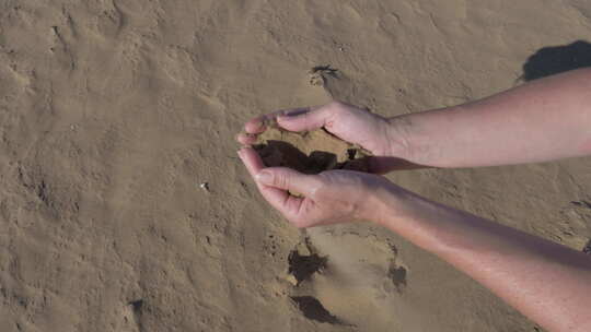 在摩洛哥捡起撒哈拉沙漠的沙子，让它从他的手指间溜走。