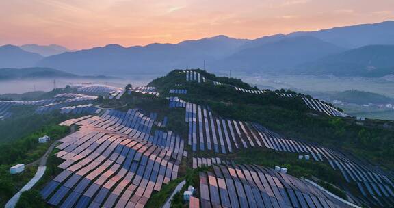 新能源太阳能光伏发电站夕阳下山坡航拍