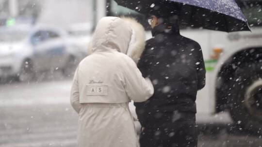 大雪天路上的情侣行人