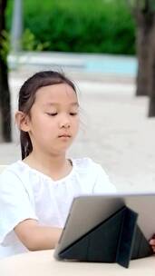 在公园使用平板电脑的女孩