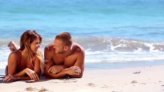 可爱的情侣躺在沙滩上