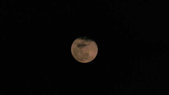 夜空中的一轮圆月在云层里穿梭