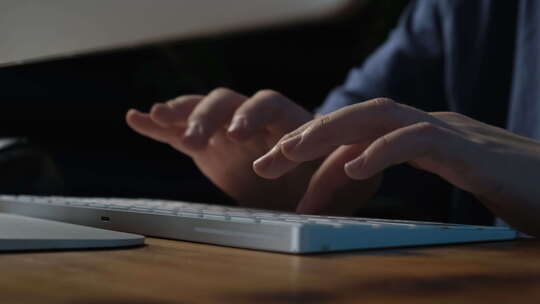 特写男性双手在键盘上打字