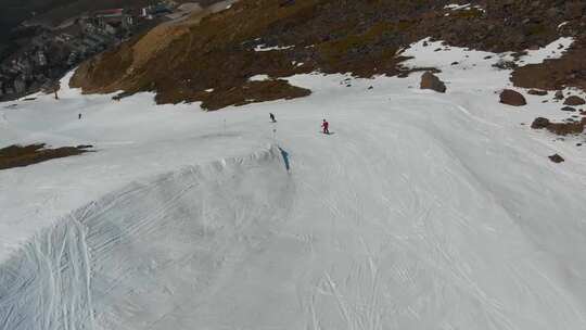 航拍特写被大雪覆盖的山脉滑雪运动者滑雪