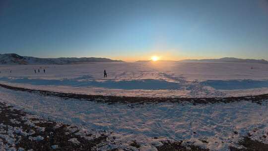 雪地夕阳下的人群与山脉