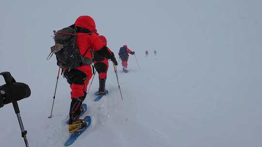 风雪中攀登慕士塔格峰雪山的登山队队员