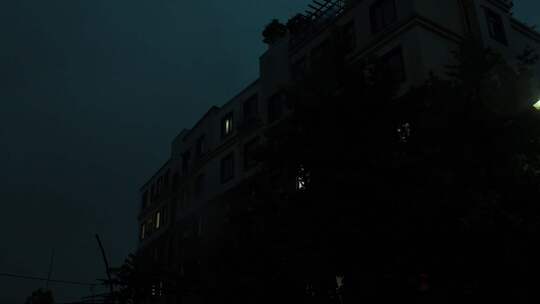 雨夜窗外的城市居民楼灯光和闪电