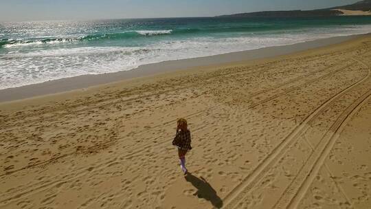 年轻女子独自走在海滩上