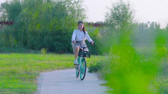 女孩在户外骑自行车的画面