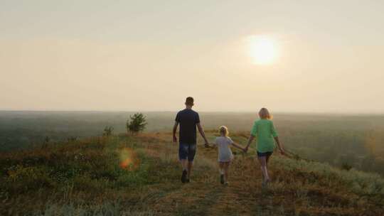 一家人夕阳下漫步草地