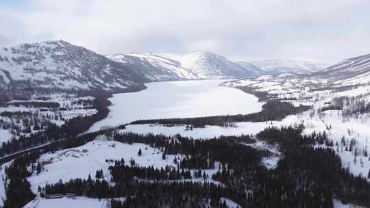 航拍新疆冬季喀纳斯湖雪景雪山森林冰河晨雾