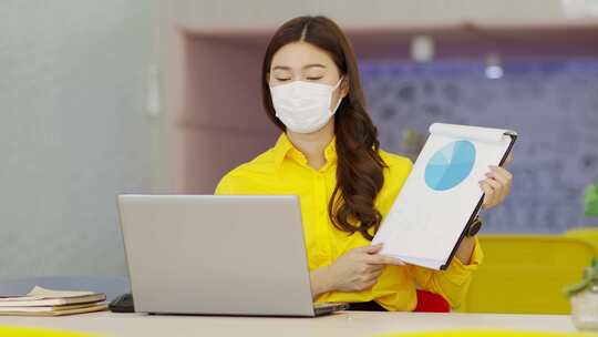 亚洲黄衬衫女性戴外科口罩的新常态通过VDO会议召开会议