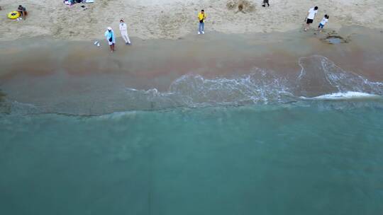 蓝天白云下的旅游胜地：三亚湾浪花拍打沙滩