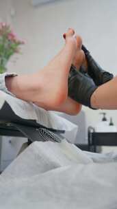 女美容师在水疗中心做足部护理后做足部按摩
