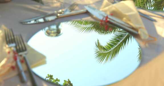 婚礼餐桌上的镜子反射着椰子树天空