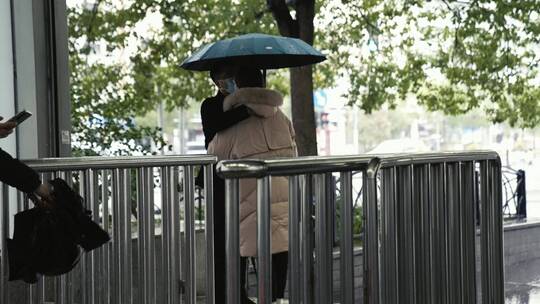 雨季下雨地铁进站路人提伞拥抱