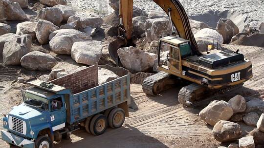 挖掘机将岩石吊人卡车
