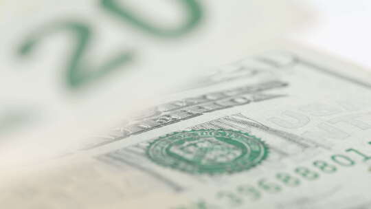 折叠的美国20美元钞票缓慢旋转。低角度
