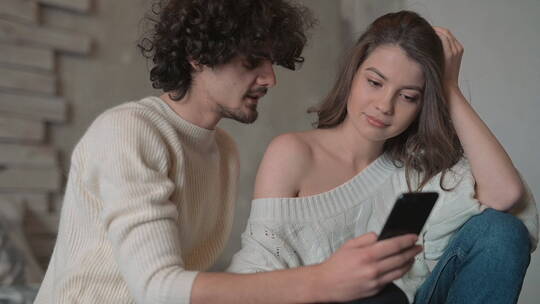 情侣在沙发上看手机视频素材模板下载