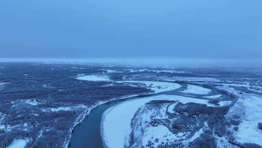 航拍晨曦中的雪原河流景观
