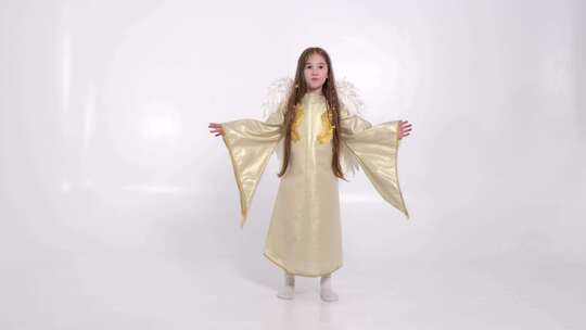 小女孩带着天使形状的白色翅膀，她正在白色